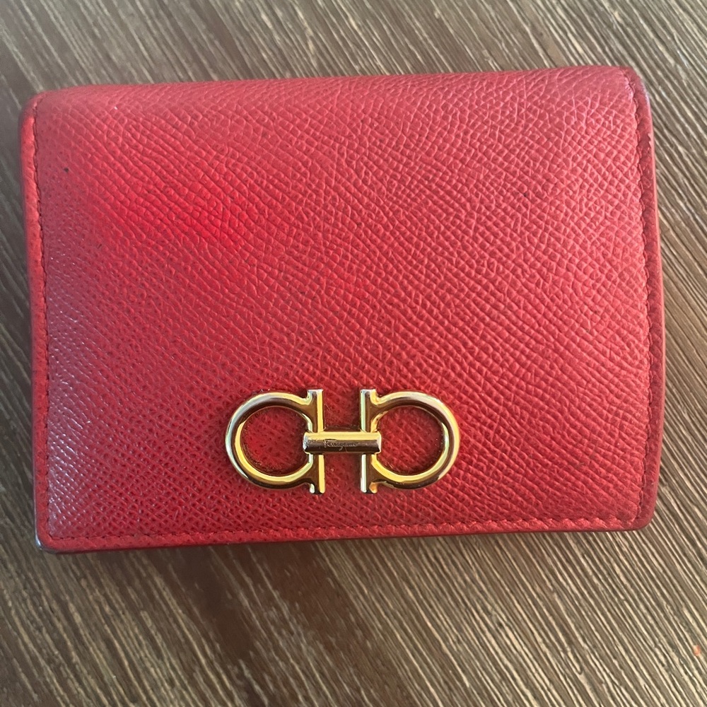Authentic FERRAGAMO Red Leather Gancini compact wallet with signature Gold Logo.